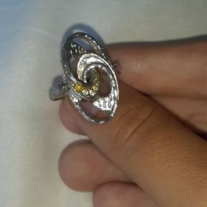 A silver colored ring with yellow little stones